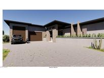 Contemporary home featuring a desert landscape, modern architecture, and a large paved driveway at 5885 St Ebbes Ct, Las Vegas, NV 89131