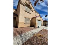 Two-story home with tan stucco and a two car garage at 6726 Montezuma Castle Ln, North Las Vegas, NV 89084