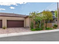 Charming home featuring an attached two car garage, brick driveway, and mature landscaping at 6934 Alexandrite Peak St, Las Vegas, NV 89148
