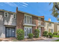 Brick townhome exterior features symmetrical balconies and landscaped front yard, on a bright day at 1034 Tam O Shanter, Las Vegas, NV 89109