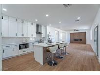 Beautiful kitchen features white cabinets, marble countertops, and a modern island with seating at 1136 Casady Hollow Ave, Henderson, NV 89012