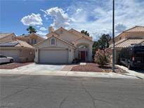 Charming single-story home with a red door, two-car garage, and landscaped front yard at 1249 Lucia Dr, Las Vegas, NV 89128