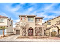 Charming two-story home with red shutters and an arched entrance, set under a bright blue, partly cloudy sky at 1324 Spice Ridge Ct, Henderson, NV 89012