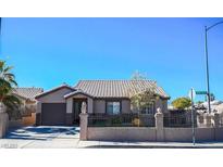 Charming single-story home featuring desert landscaping and a decorative wrought iron fence at 1713 Golden Sky Dr, Las Vegas, NV 89106