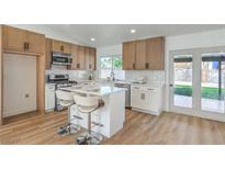 Bright kitchen features modern stainless steel appliances, wood cabinets, white countertops, and breakfast bar seating at 2529 Indian Sage Way, Las Vegas, NV 89108