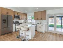Bright kitchen features stainless steel appliances, white countertops, and a center island with bar seating at 2529 Indian Sage Way, Las Vegas, NV 89108