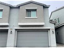 Two-story townhome featuring a gray exterior and a two-car garage at 2585 Amazing Meadows Ave # 1007, North Las Vegas, NV 89031