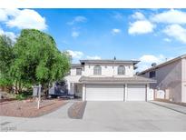 Charming two-story home with a three-car garage, arched windows, and a well-manicured front yard at 2808 Deep Water Cir, Las Vegas, NV 89117