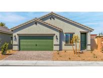 Charming single-story home with a green garage door, desert landscaping, and a brick-paved driveway at 3241 Walker River St, North Las Vegas, NV 89032