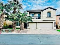 Two-story home with a balcony, two-car garage, palm trees, and stone accents at 7109 Rancho De Taos, Las Vegas, NV 89130
