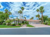 Beautiful home showcasing lush landscaping and a driveway leading to a three-car garage at 72 Innisbrook Ave, Las Vegas, NV 89113