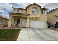 Two-story home with a tan exterior, white trim, two-car garage and a neatly kept lawn at 10071 Lemon Valley Ave, Las Vegas, NV 89147