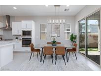 Bright dining area features a modern chandelier and easy access to the outdoor space through sliding glass doors at 10251 Tiger Milkweed St, Las Vegas, NV 89141