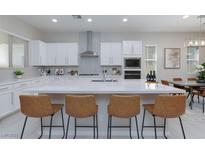 Bright kitchen with white cabinets, quartz countertops, stainless steel appliances, and seating at the large island at 10251 Tiger Milkweed St, Las Vegas, NV 89141