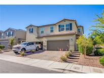 Charming two-story home featuring a two-car garage, a well-maintained yard, and a brick driveway at 104 Pollentia Ave, North Las Vegas, NV 89084