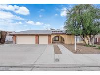 Charming single-story home featuring a two-car garage, an arched entryway and mature shade tree at 1913 Piccolo Way, Las Vegas, NV 89146