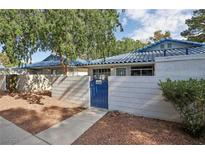 Charming single-story home with blue tile roof, gated courtyard, and mature trees in a well-maintained community at 2128 Petersham Ct # C, Las Vegas, NV 89108