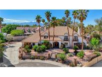 Expansive home featuring a clay tile roof, lush landscaping, and mature palm trees at 2771 S Buffalo Dr, Las Vegas, NV 89117