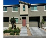 Modern townhome featuring a warm toned front door, attached garage, and low-maintenance landscaping at 2872 Atomic Tangerine Way # 2, Las Vegas, NV 89183