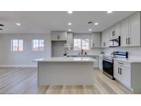 Modern kitchen features sleek gray cabinets, stainless steel appliances, and quartz countertops with an island at 4360 El Tovar Rd, Las Vegas, NV 89115