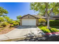 Charming single-story home featuring a well-maintained lawn, two-car garage, and desert landscaping at 504 Painted Cloud Pl, Las Vegas, NV 89144