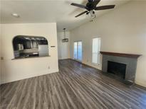 Bright living room with fireplace, modern ceiling fan, and doorway to backyard at 611 Bass Dr # C, Henderson, NV 89014