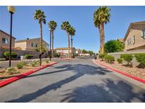 View of the community entrance with palm trees and well-maintained landscaping on a sunny day at 6420 Extreme Shear Ave # 102, Henderson, NV 89011