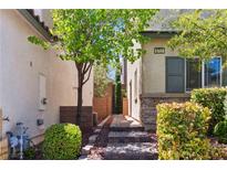 Inviting front entrance with stone accents, manicured landscaping, and charming gated walkway to private courtyard at 6731 Sumatra St, Las Vegas, NV 89166