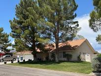 Charming single-story home featuring a well-manicured lawn and mature trees at 7650 Butterscotch Ct, Las Vegas, NV 89131