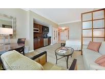 Comfortable living room with kitchenette featuring modern appliances, wooden cabinets and stylish decor at 125 E Harmon Ave # 318, Las Vegas, NV 89109