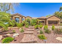 Beautiful single-story home featuring lush landscaping and a brick walkway leading to the front door at 1564 Fieldbrook St, Henderson, NV 89052
