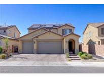 Charming two-story home with a three-car garage and solar panels under a clear blue sky at 242 Polaris Ridge Ave, Henderson, NV 89011