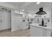 Modern kitchen with white cabinetry, stainless steel appliances, and light wood flooring at 2461 Old Forge Ln # 103, Las Vegas, NV 89121