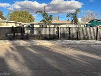 View of home featuring a gated entrance with mature landscaping and a blue sky overhead at 321 Beaumont St, Las Vegas, NV 89106