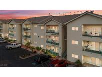 Inviting condo building with tan siding and balconies with decorative railings, surrounded by lush greenery and ample parking at 3550 Bay Sands Dr # 2101, Laughlin, NV 89029