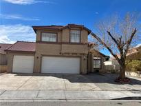 Two story home features a red tile roof, multi car garage, and a low maintenance front yard at 5255 Autumn Sky Rd, Las Vegas, NV 89118