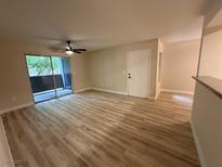 Bright living room features wood-look floors, balcony access, and a modern ceiling fan at 555 E Silverado Ranch Blvd # 1034, Las Vegas, NV 89183