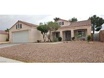Single story home with desert landscaping, covered porch, dormer windows and a two car garage at 5900 Red Umber Ave, Las Vegas, NV 89130