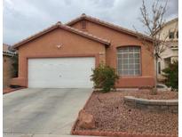 Charming single-story home with a two-car garage, tiled roof, and a well-maintained front yard at 7535 Frontier Ranch Ln, Las Vegas, NV 89113