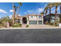 Stunning two-story home featuring a large driveway, desert landscaping, and a symmetrical facade at 7616 Gossamer Wind St, Las Vegas, NV 89139