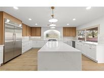 Bright kitchen features large island, stainless steel refrigerator, and ample countertop space at 7616 Gossamer Wind St, Las Vegas, NV 89139