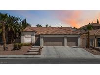 Charming single-story home features a three-car garage, desert landscaping, and a tile roof at 8326 Mount Nido Dr, Las Vegas, NV 89147