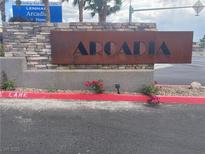 Arcadia community entrance sign made of stone and metal with decorative flowers at 3534 Alpheus River Ave, Las Vegas, NV 89106