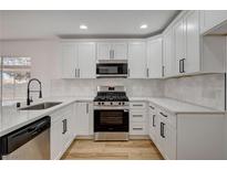 Bright kitchen features white cabinets, stainless steel appliances, and modern finishes, perfect for cooking and entertaining at 5466 Silverheart Ave, Las Vegas, NV 89142