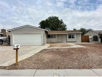 Charming single-story home with an attached garage and low-maintenance landscaping at 1004 Stone River Dr, North Las Vegas, NV 89030