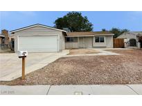 Cozy home featuring a two-car garage, complemented by a tidy, low-maintenance front yard landscape at 1004 Stone River Dr, North Las Vegas, NV 89030