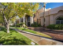 Elegant home exterior featuring lush landscaping, mature trees, and a circular driveway at 1008 Trophy Hills Dr, Las Vegas, NV 89134