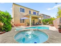 Inviting backyard features a sparkling pool, hot tub, covered patio and lush landscaping perfect for outdoor living at 10823 Drake Ridge Ave, Las Vegas, NV 89166