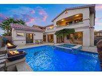 Inviting pool area with spa, fire bowls, and umbrella, creating a luxurious backyard retreat at 12219 Crystal Shore Ave, Las Vegas, NV 89138