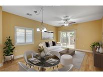 Bright dining area featuring a modern light fixture, round table and view to the living area and backyard at 1435 Orange Jubilee Rd, Henderson, NV 89014